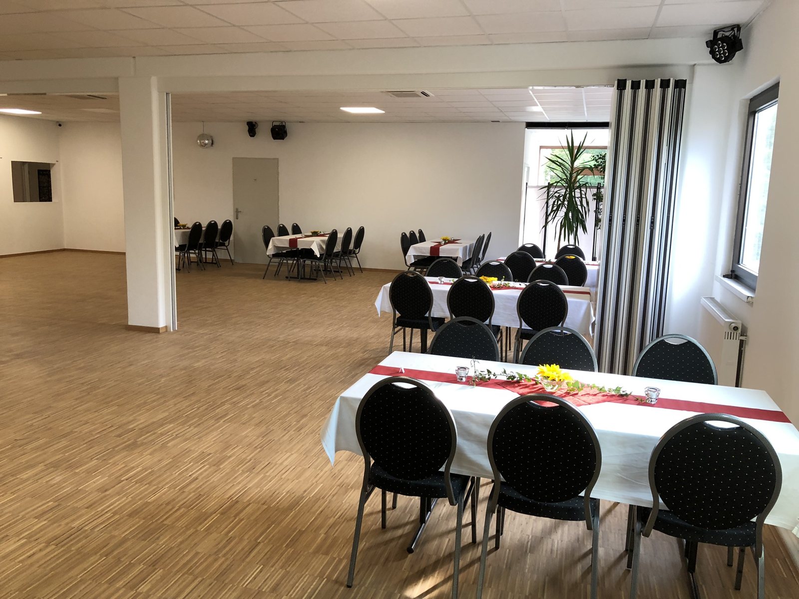 Festlich eingedeckte Tafel mit weinroten Servietten und Kerzen