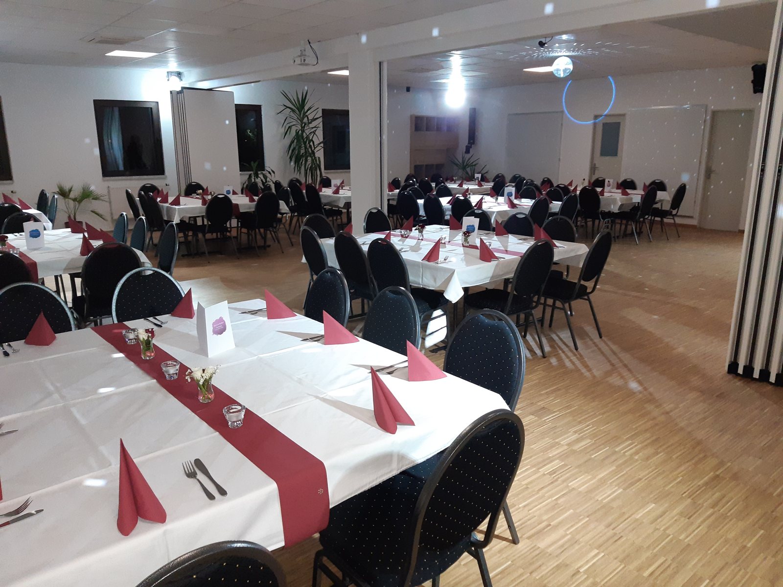 Blick durch den Festsaal ueber die gedeckten Tafeln zur Tanzflaeche
