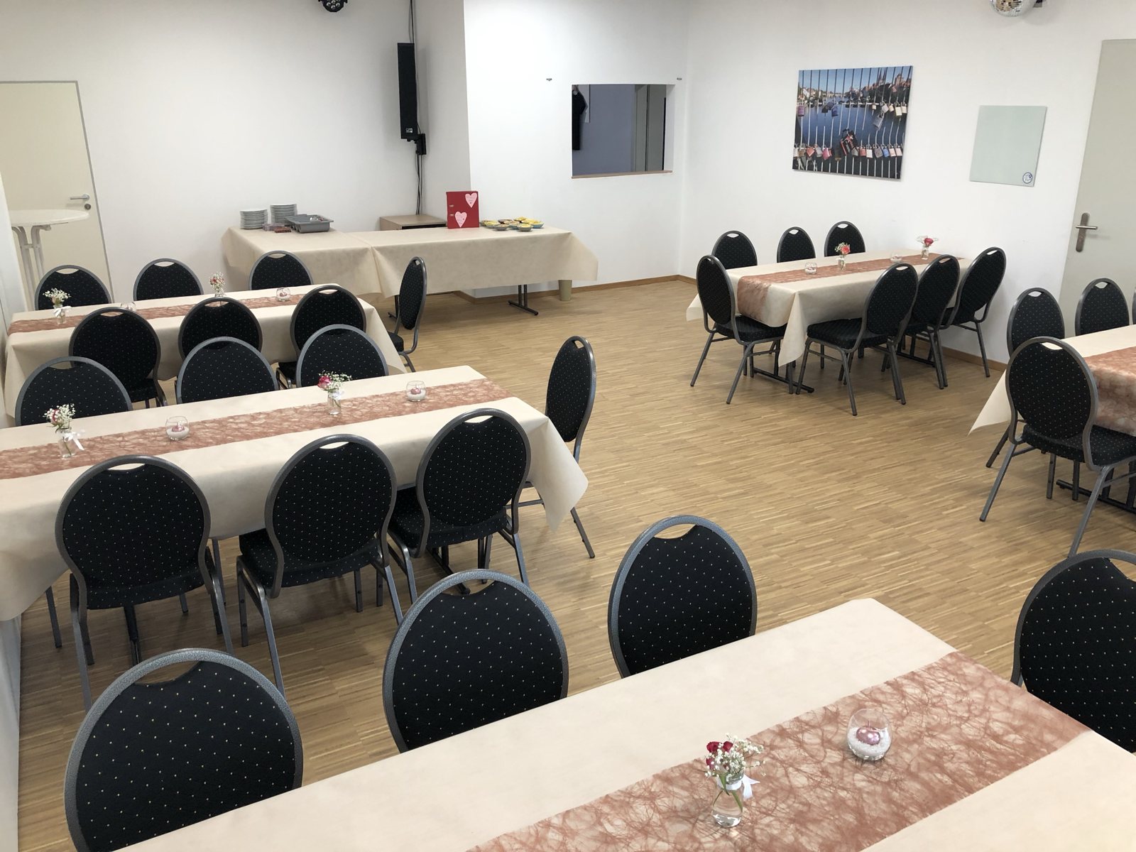 Tische im Saal rechts mit Tischlaeufern und Blumenschmuck