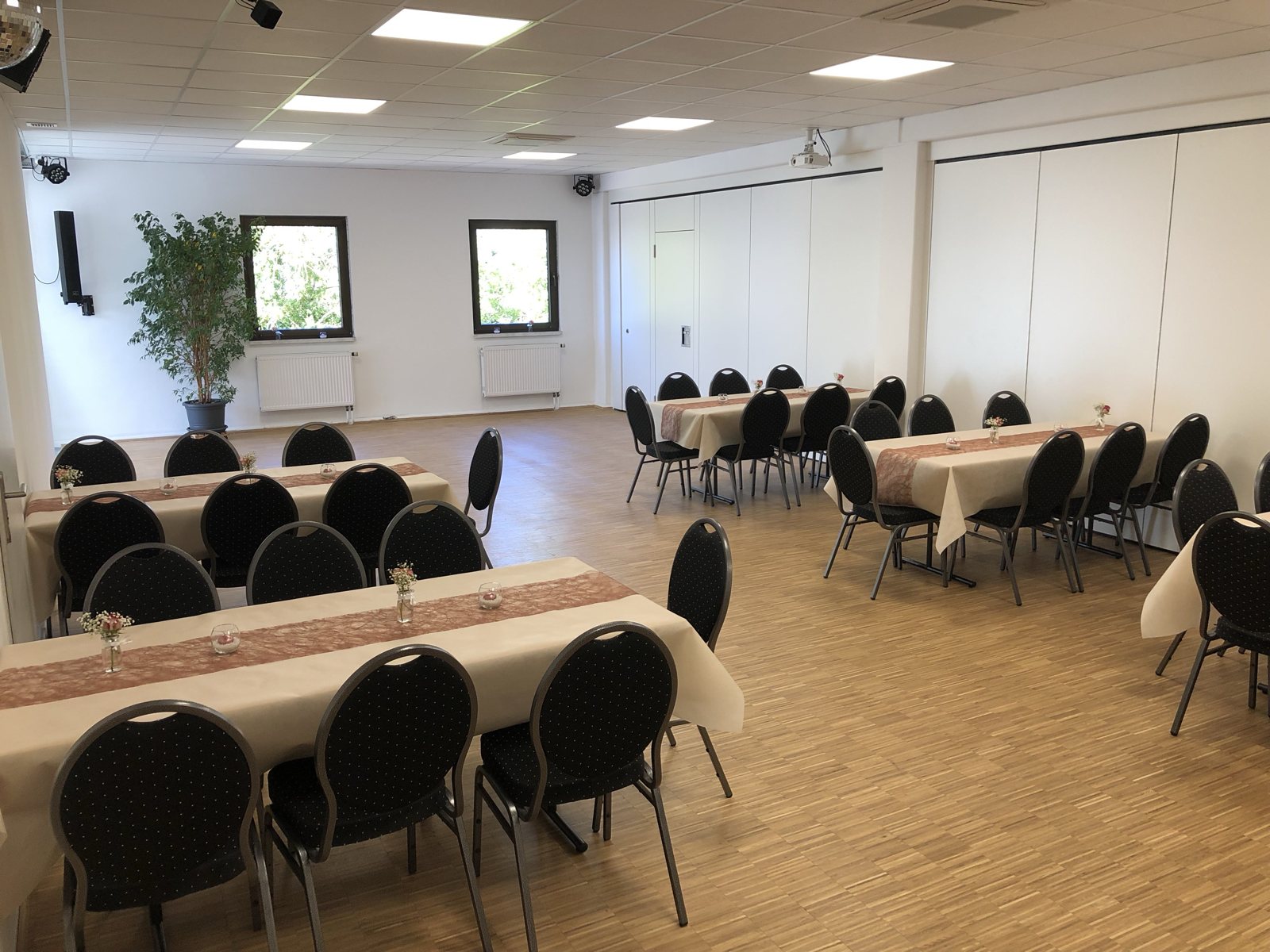 Saal rechts mit gedeckten Tafeln und Tageslicht durch die Fenster